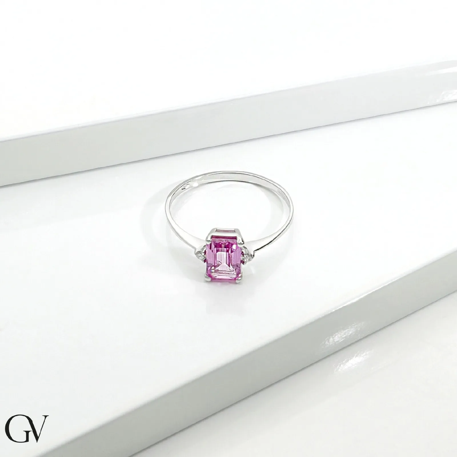 Anello in oro bianco 18k con zaffiro rosa e un diamante per lato